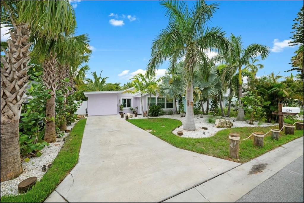 1210 Bay Palm Boulevard Indian Rocks Beach, FL 33785 - Photo 2 of 19 a view of a house with a yard and palm trees