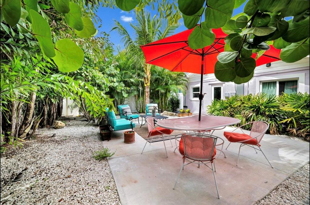 1210 Bay Palm Boulevard Indian Rocks Beach, FL 33785 - Photo 4 of 19 a view of a patio with chairs and table under an umbrella