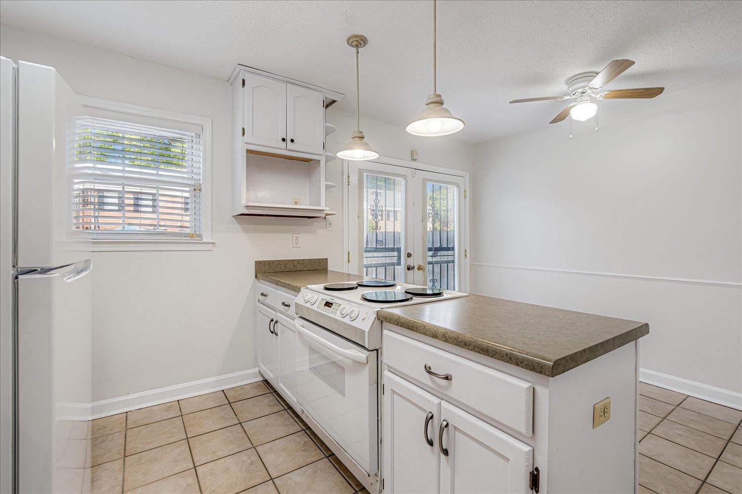 5696 Quince Road, Unit 1 Memphis, TN 38119 - Photo 1 of 26 Kitchen featuring a peninsula, white appliances, white cabinetry, light tile patterned flooring, and decorative light fixtures
