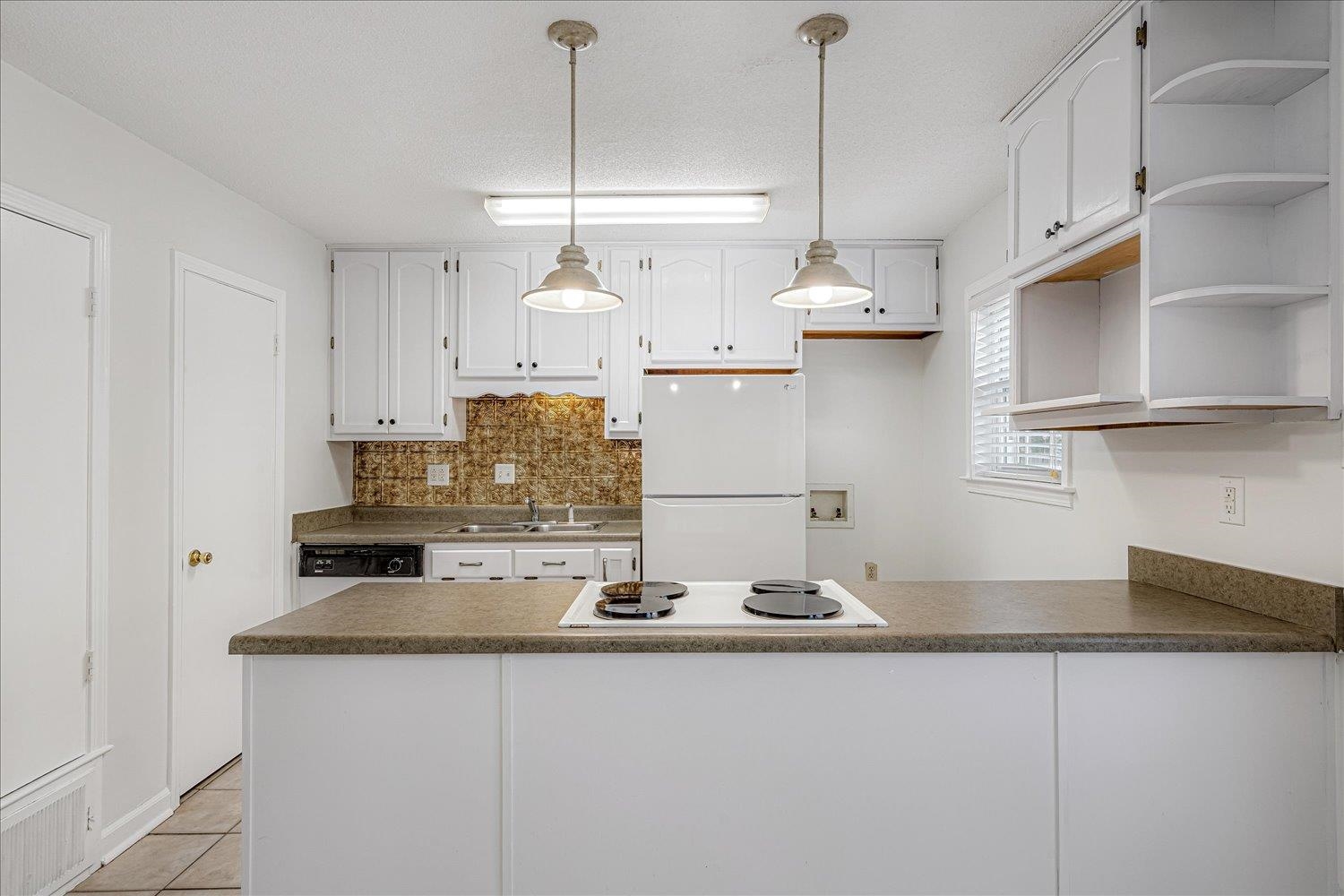 5696 Quince Road, Unit 1 Memphis, TN 38119 - Photo 20 of 26 Kitchen with open shelves, backsplash, white appliances, a peninsula, and a textured ceiling