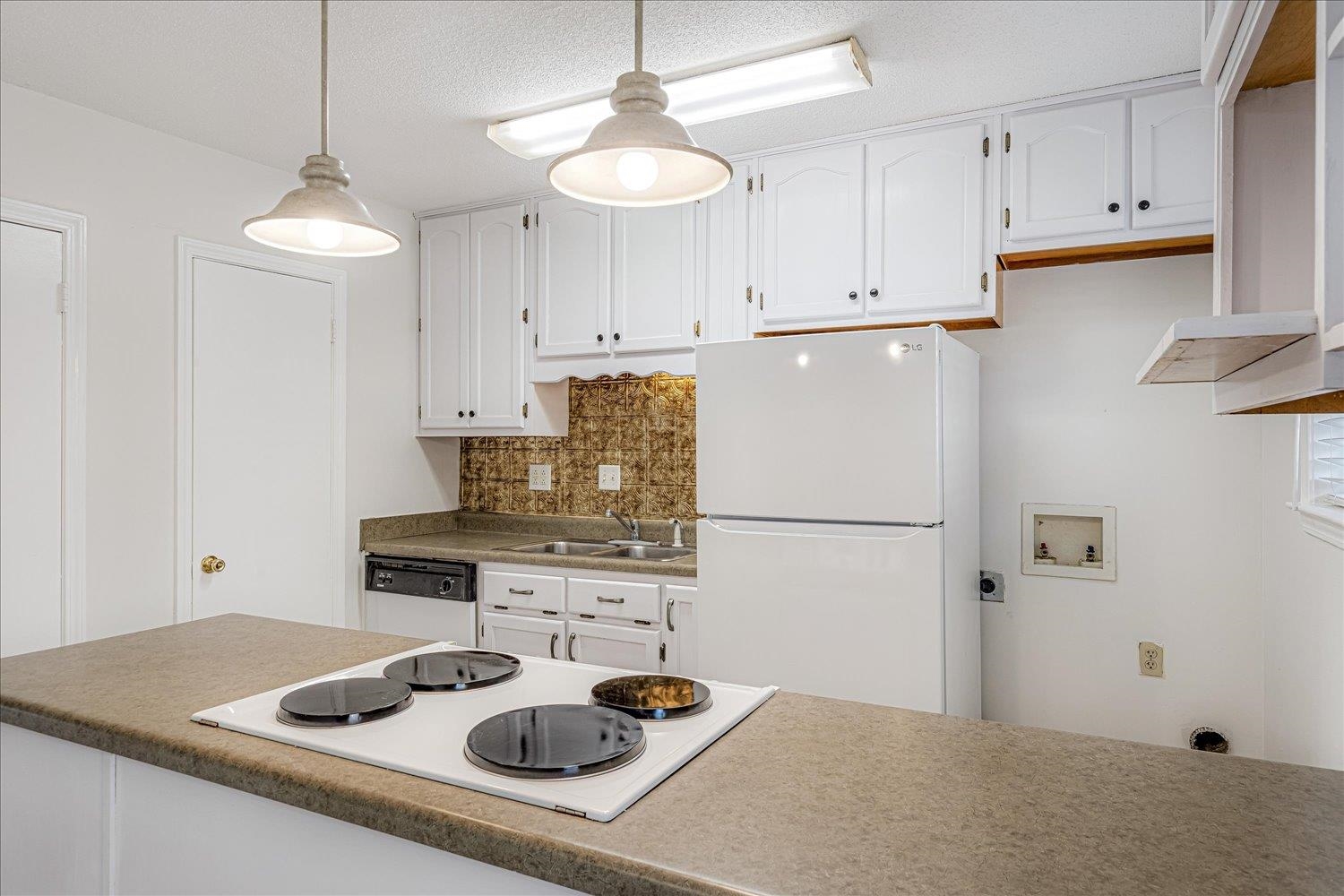 5696 Quince Road, Unit 1 Memphis, TN 38119 - Photo 3 of 26 Kitchen with white appliances, decorative backsplash, white cabinets, pendant lighting, and dark countertops