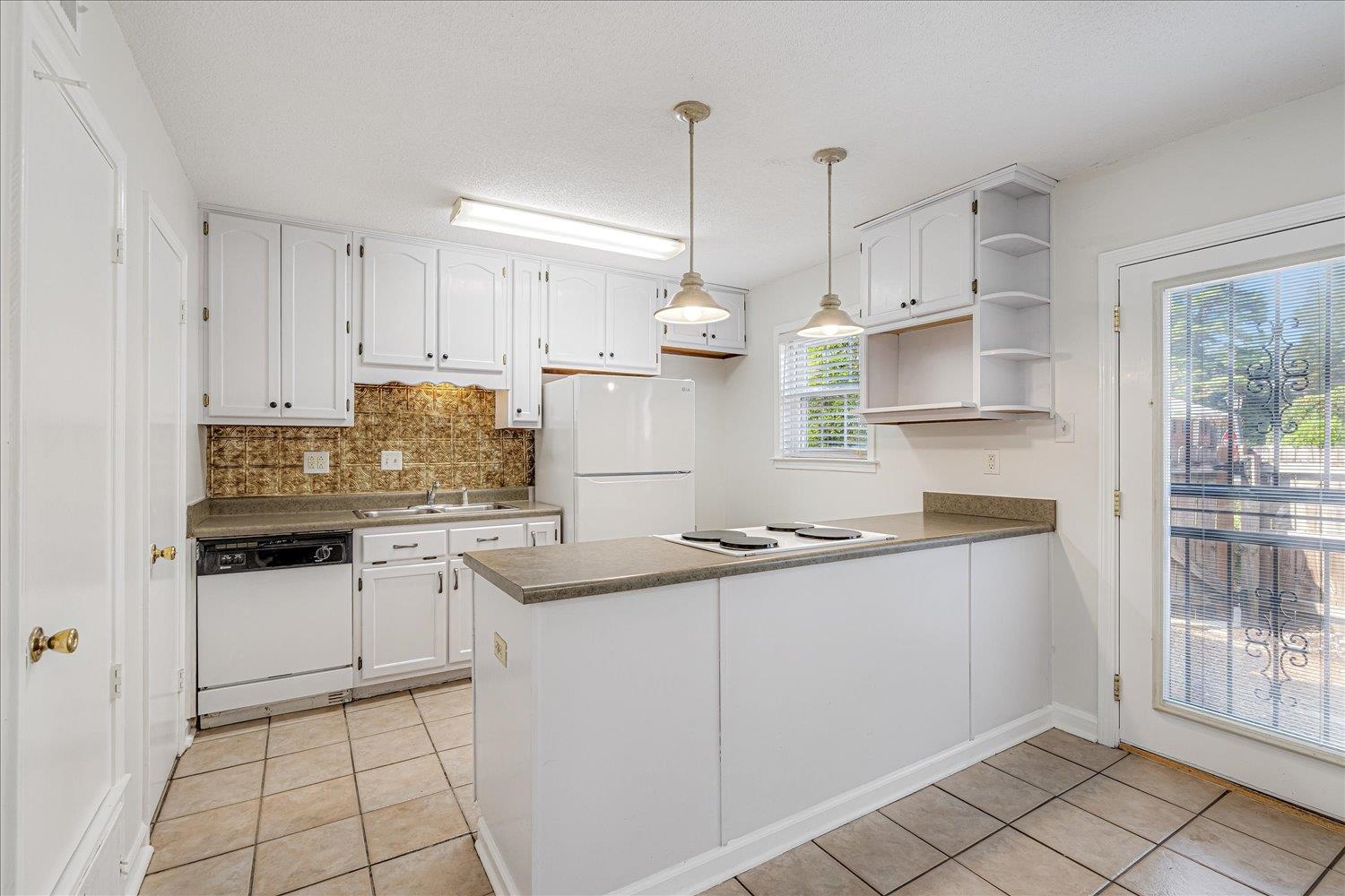 5696 Quince Road, Unit 1 Memphis, TN 38119 - Photo 8 of 26 Kitchen with decorative backsplash, light tile patterned flooring, and white cabinetry