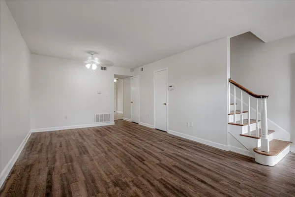 a view of empty room with wooden floor