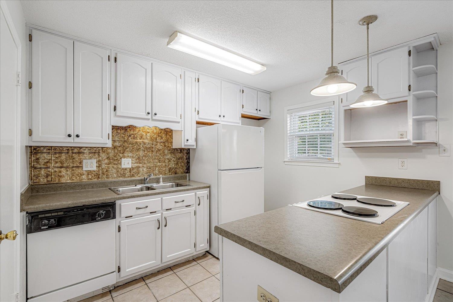 5696 Quince Road, Unit 1 Memphis, TN 38119 - Photo 9 of 26 Kitchen with open shelves, white appliances, hanging light fixtures, tasteful backsplash, and white cabinetry
