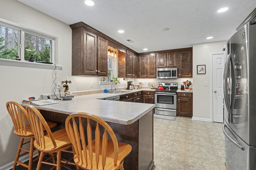 4790 Fires Creek Road Hayesville, NC 28904 - Photo 16 of 61 a kitchen with kitchen island a stove a sink a refrigerator dining table and chairs