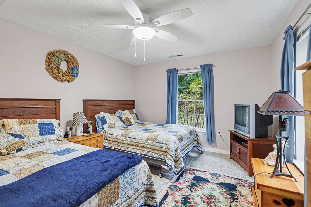 4790 Fires Creek Road Hayesville, NC 28904 - Photo 32 of 61 a bedroom with two beds and a chandelier