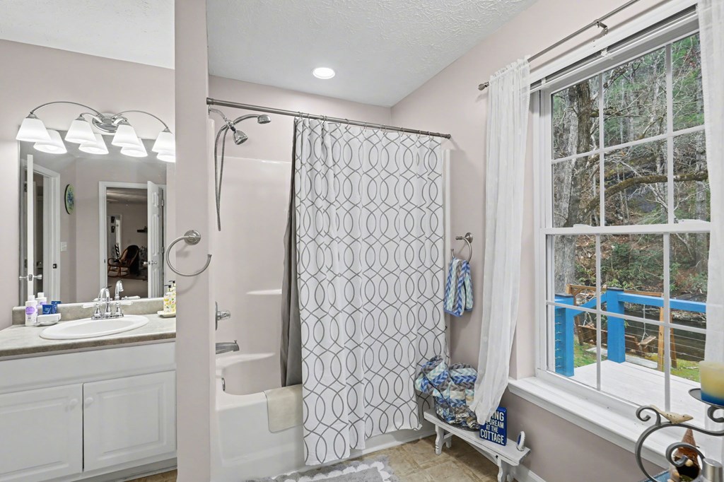 4790 Fires Creek Road Hayesville, NC 28904 - Photo 36 of 61 a bathroom with a granite countertop sink mirror and shower