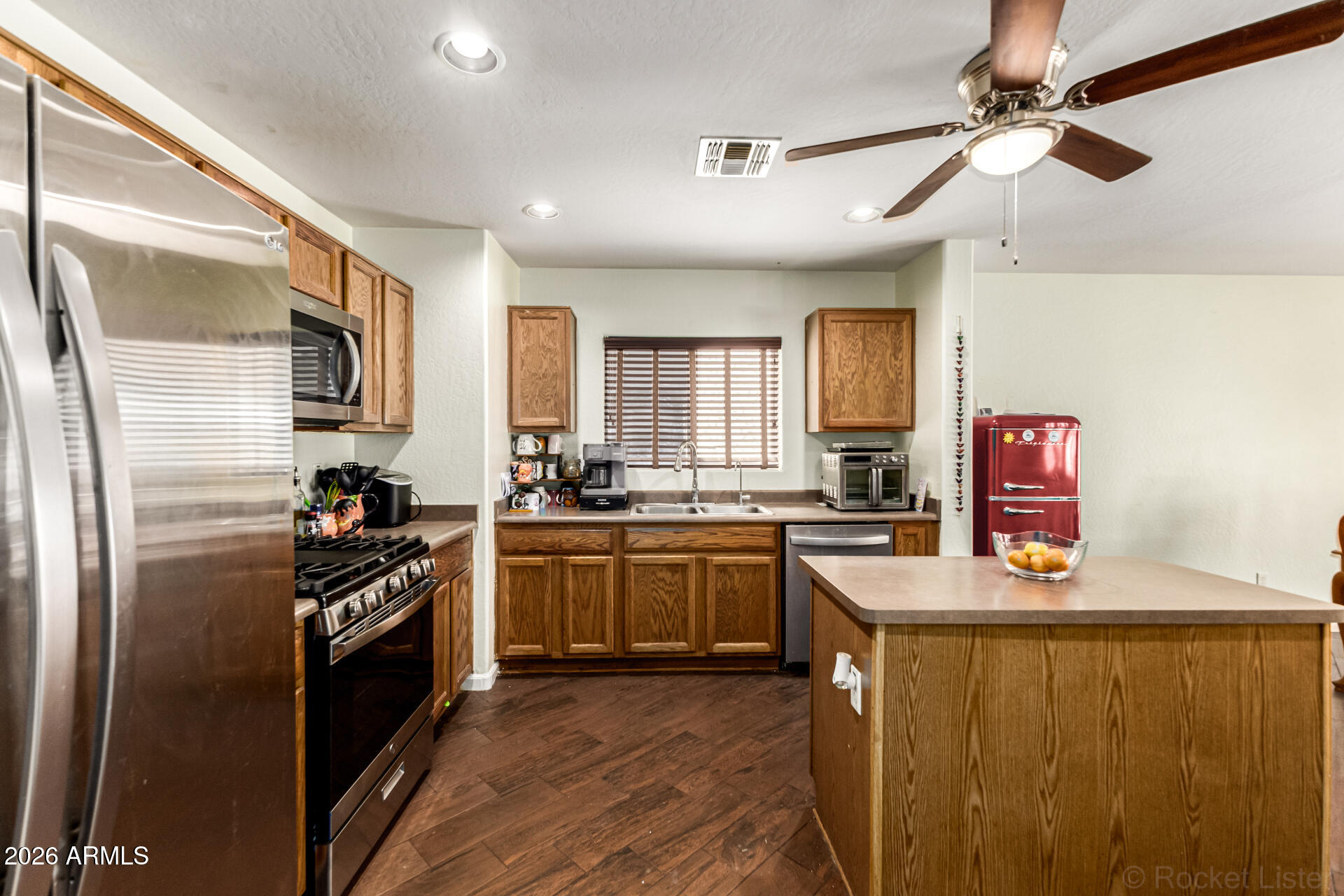 40264 West Lococo Street Maricopa, AZ 85138 - Photo 23 of 29 a kitchen with stainless steel appliances granite countertop a refrigerator a stove a sink and dishwasher