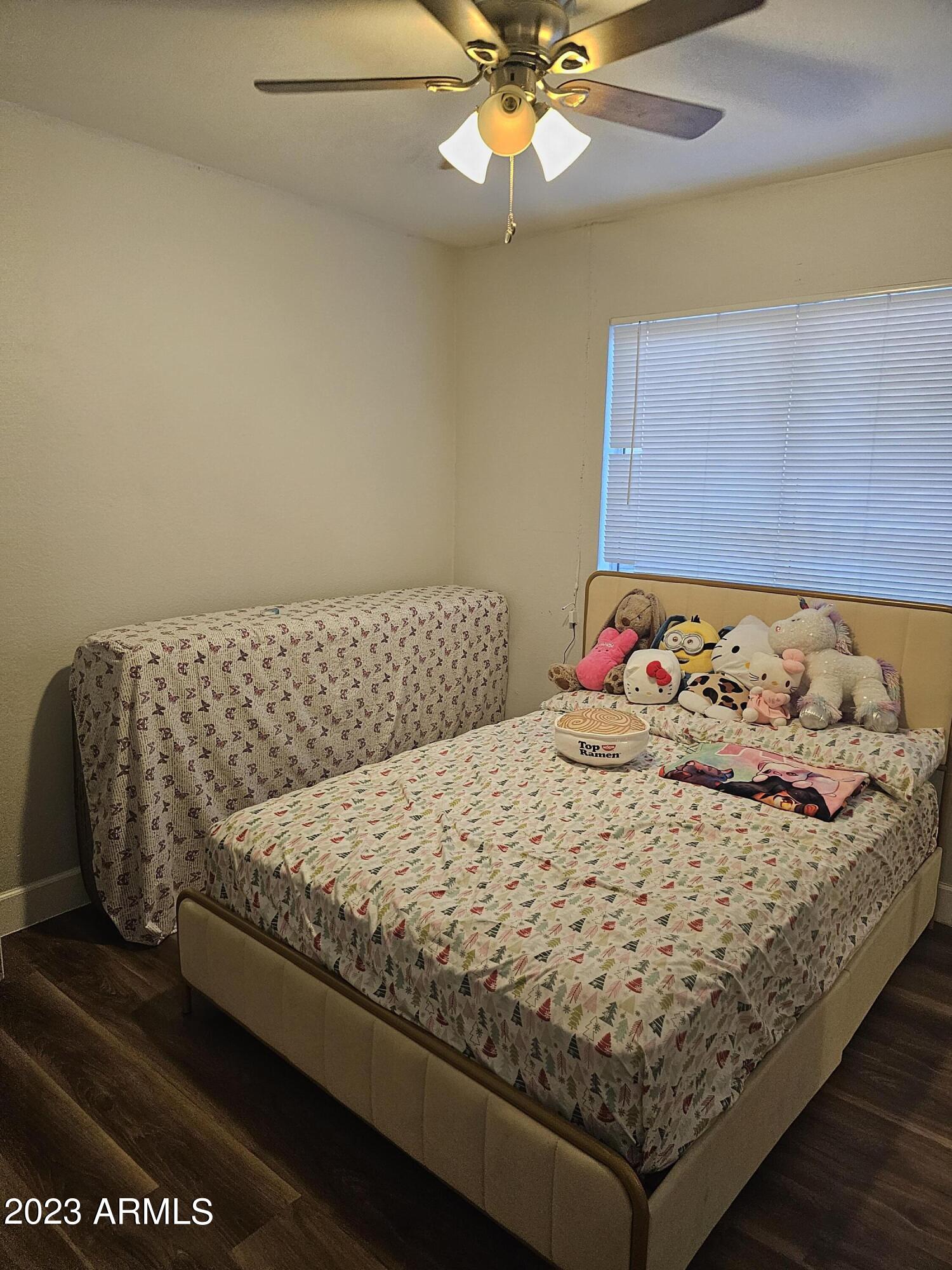 8738 West Granada Road Phoenix, AZ 85037 - Photo 7 of 13 a bed sitting in a bedroom next to a window