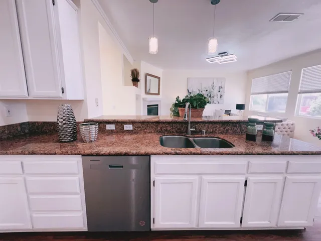 a kitchen with granite countertop a sink and cabinets