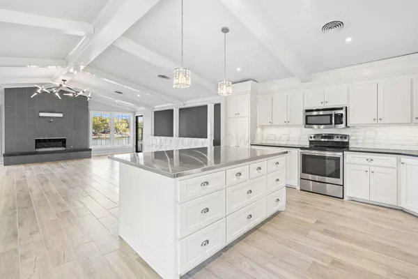 a kitchen with granite countertop a sink stainless steel appliances and cabinets