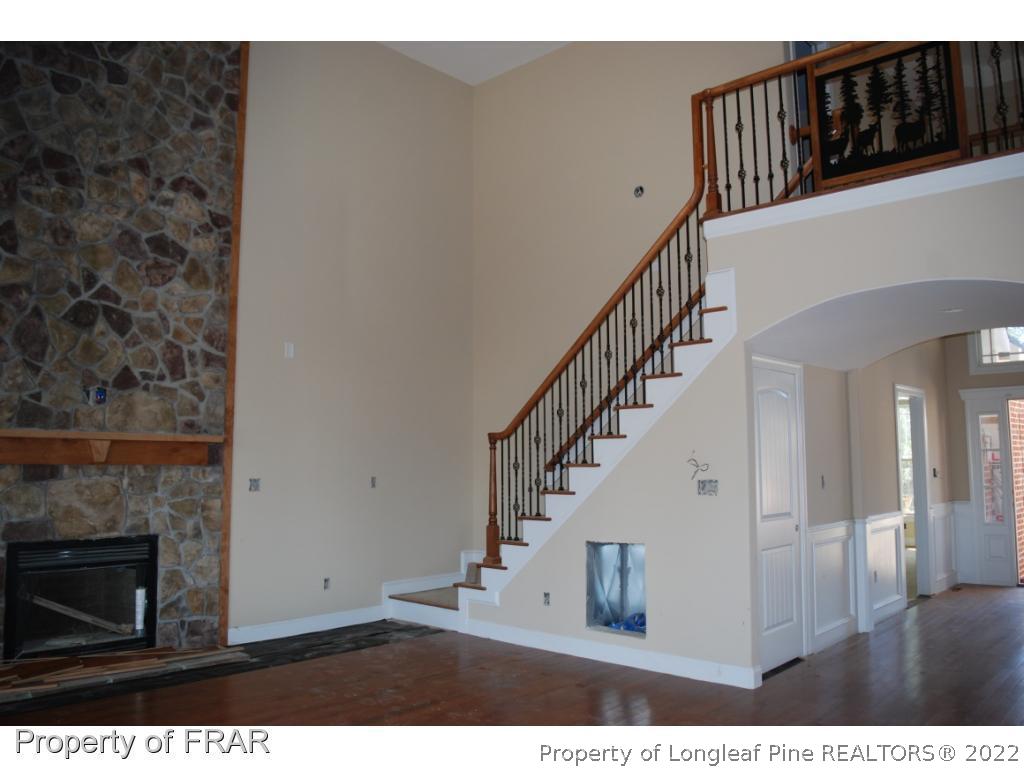 270 Falling Water Road Spring Lake, NC 28390 - Photo 33 of 34 a view of a livingroom with wooden floor stairs and a fireplace