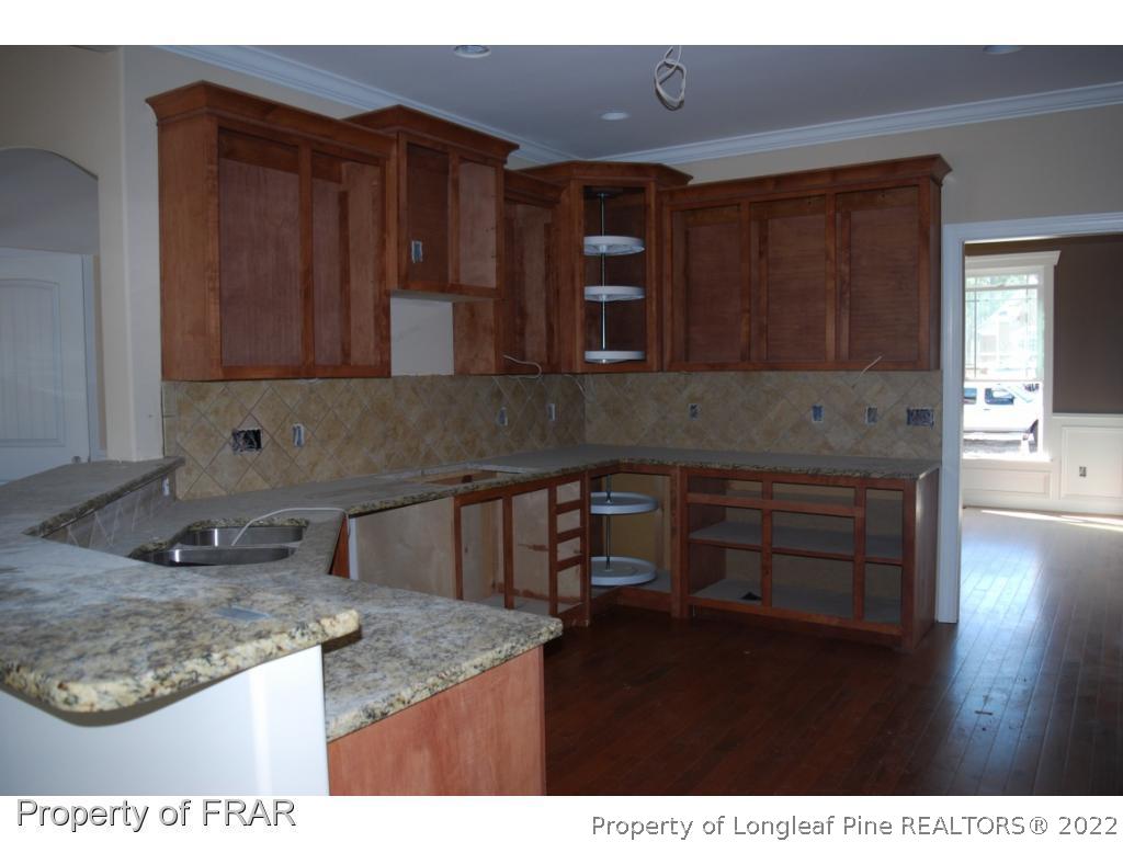 270 Falling Water Road Spring Lake, NC 28390 - Photo 7 of 34 a kitchen with kitchen island granite countertop wooden cabinets a sink and dishwasher
