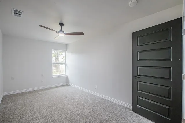 a view of an empty room with a ceiling fan