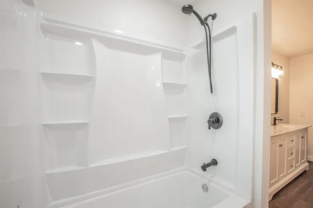 a view of an empty room with wooden floor