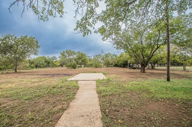 a front view of a house with a garden and trees
