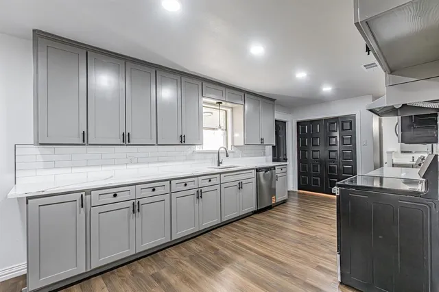 a large kitchen with lot of cabinets and wooden floor