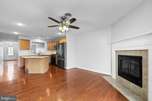 a view of large kitchen with a fireplace and wooden floor