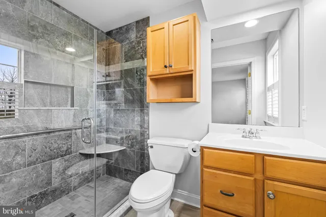 a bathroom with a sink a toilet and shower