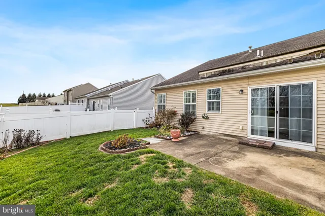 a view of a backyard with table and chairs and a large tree