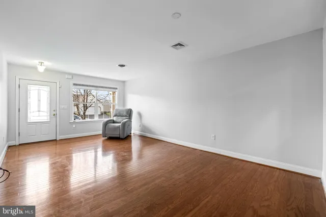 a view of a livingroom with wooden floor and a rug