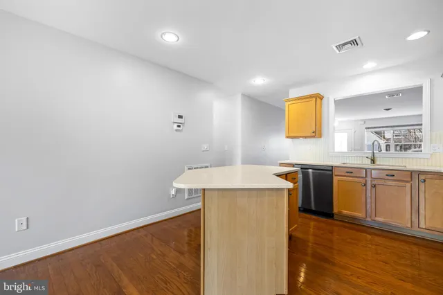 a kitchen with a sink cabinets and wooden floor
