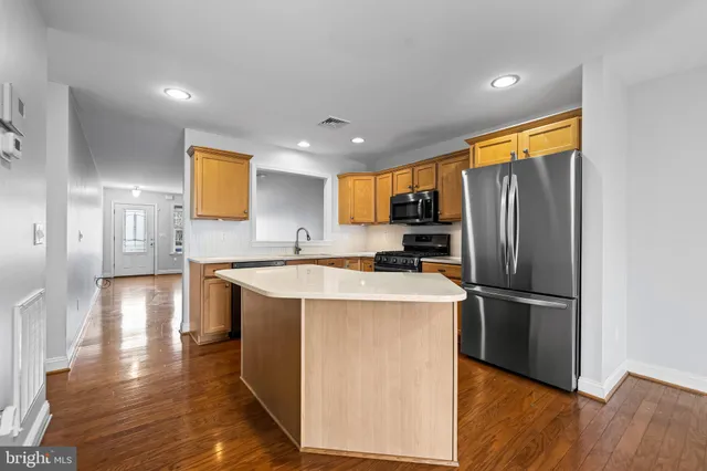 a kitchen with stainless steel appliances granite countertop a refrigerator a sink and a stove