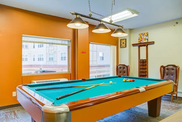 a room with pool table and windows