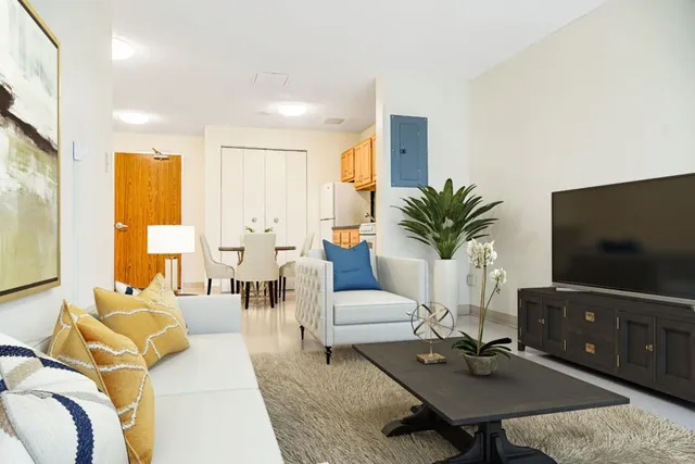 a living room with furniture a flat screen tv and a large window