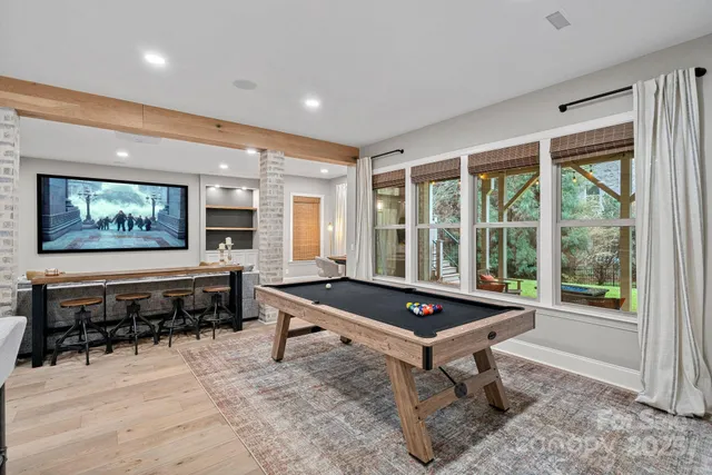 a living room with furniture a rug and a floor to ceiling window
