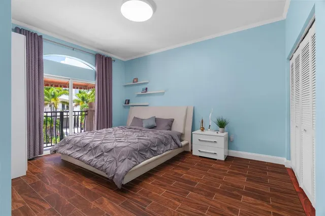 a bedroom with a bed and wooden floor
