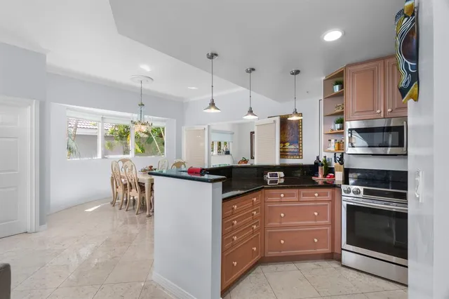 a kitchen with granite countertop white cabinets and stainless steel appliances