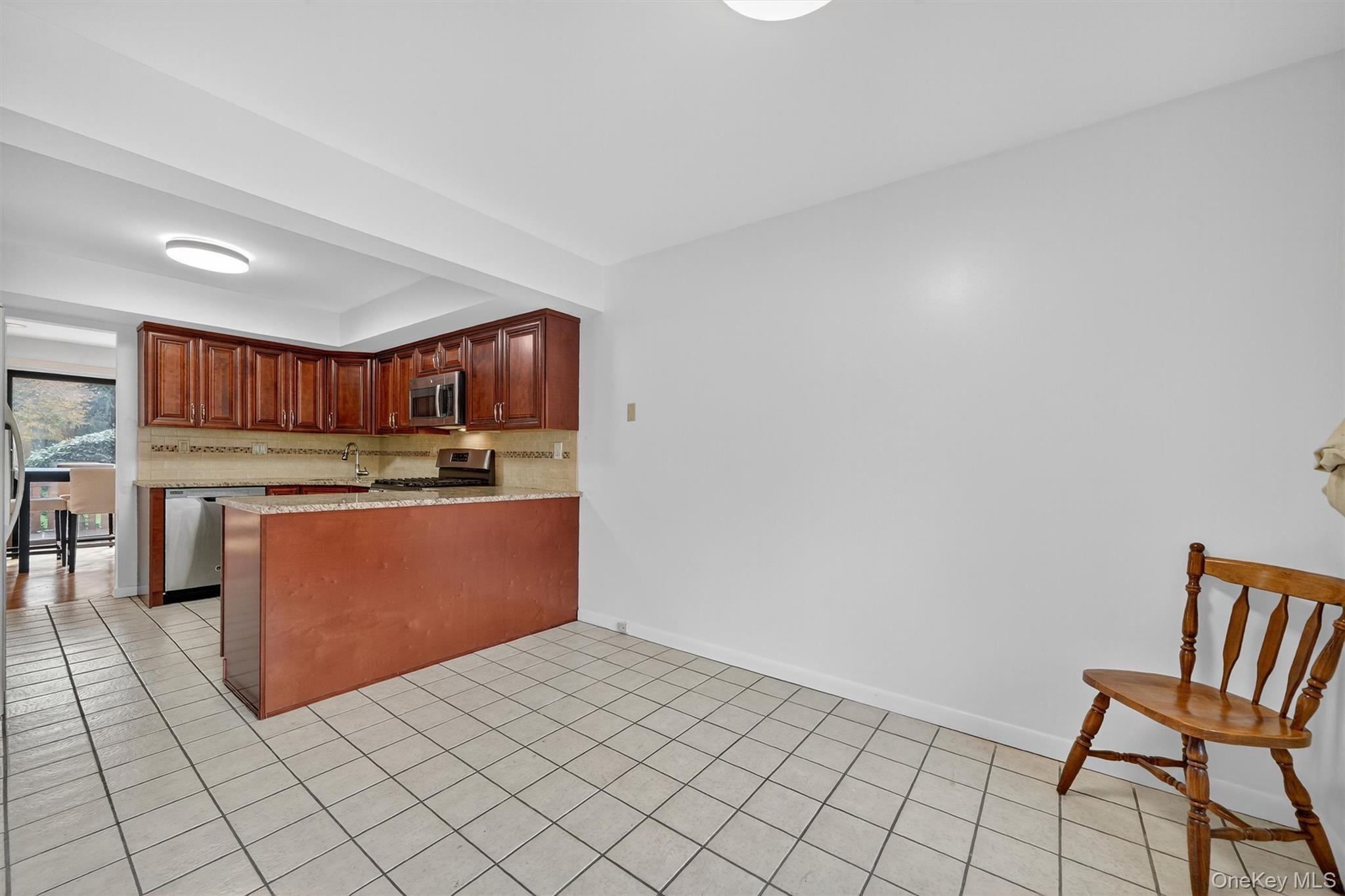 200 California Road, Unit 9 Mount Vernon, NY 10552 - Photo 3 of 50 a kitchen with stainless steel appliances granite countertop a refrigerator and a stove top oven