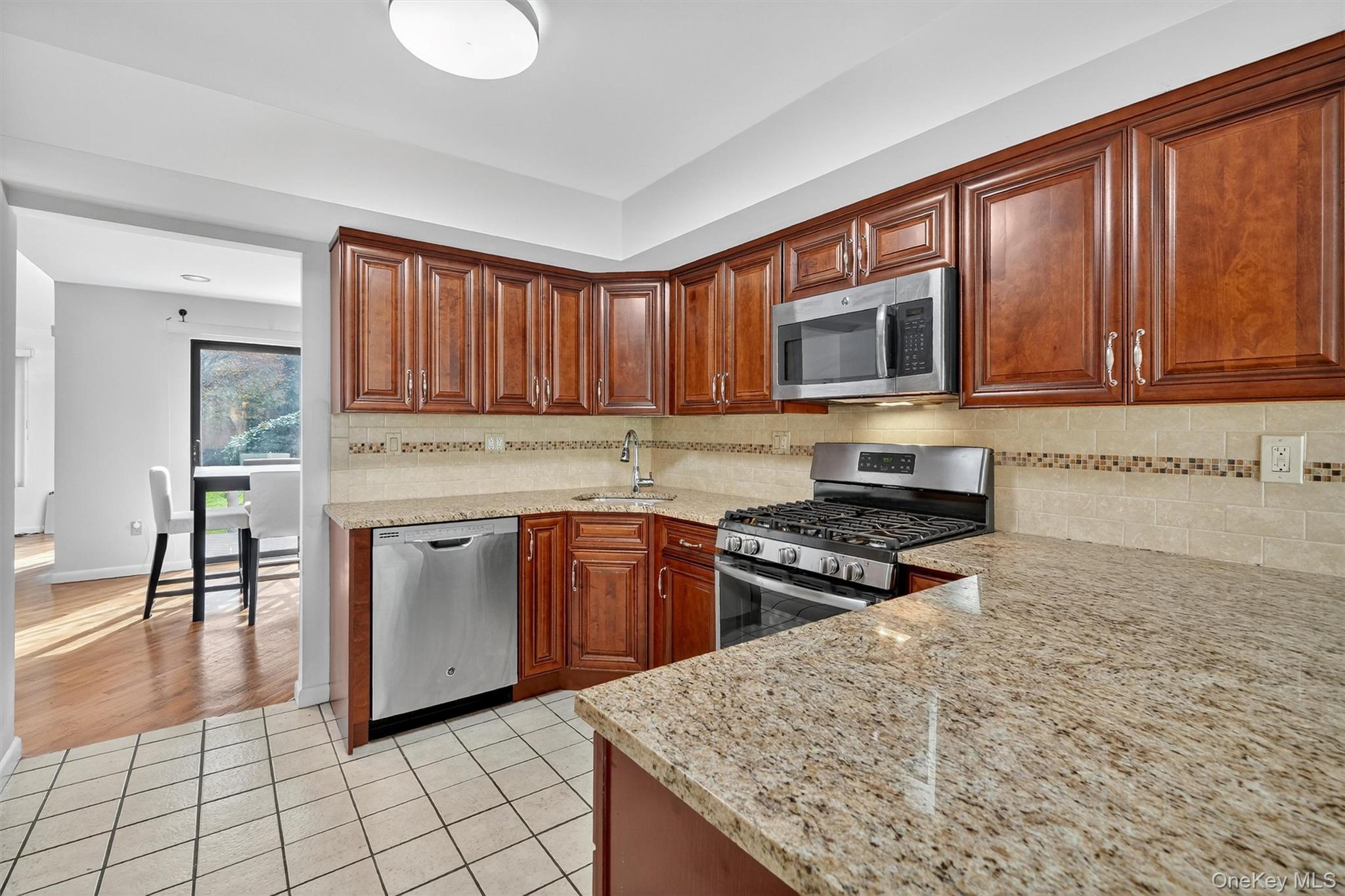 200 California Road, Unit 9 Mount Vernon, NY 10552 - Photo 8 of 50 a kitchen with granite countertop a stove top oven microwave and cabinets
