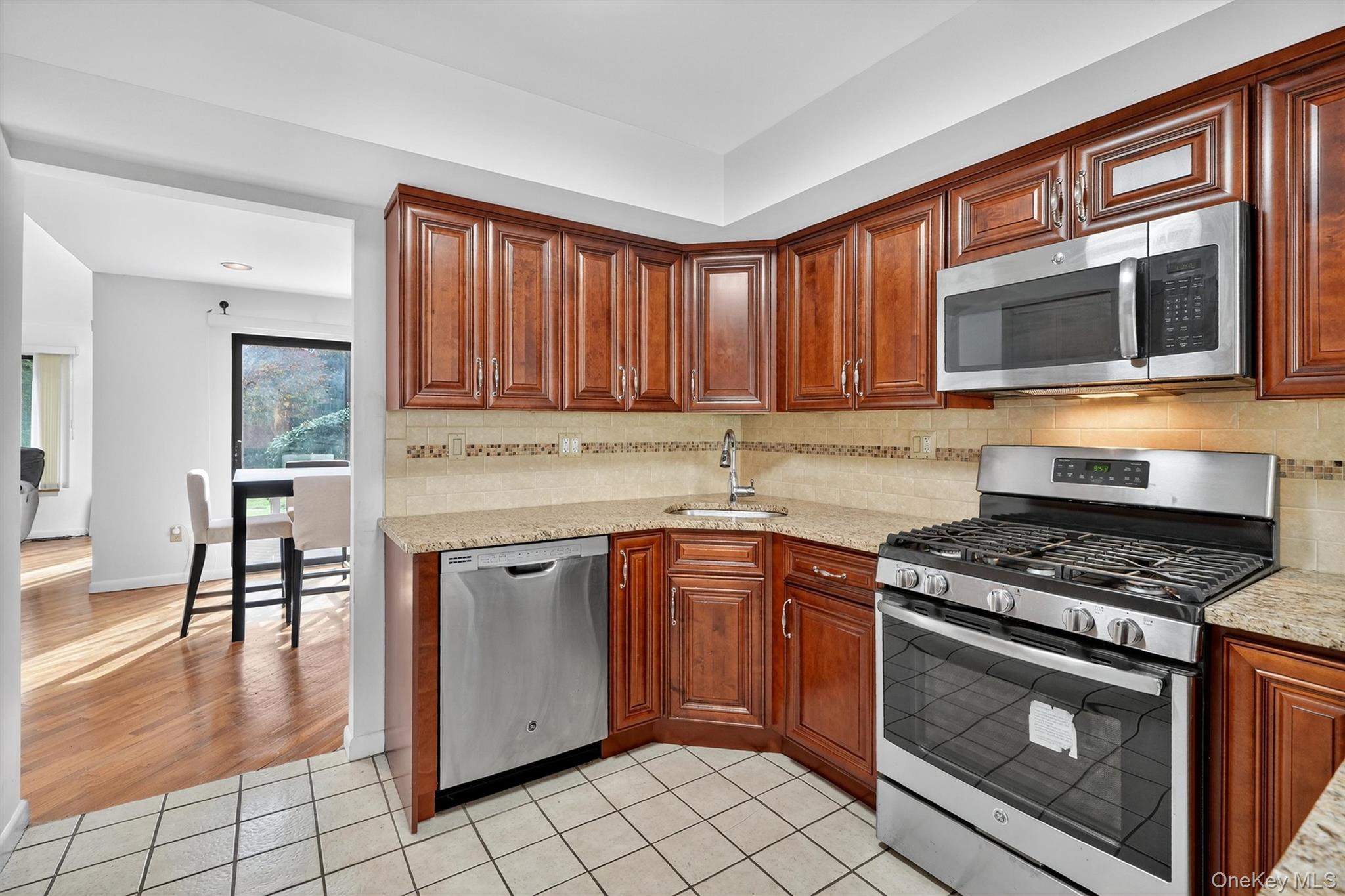 200 California Road, Unit 9 Mount Vernon, NY 10552 - Photo 9 of 50 a kitchen with stainless steel appliances granite countertop a stove a sink and a microwave