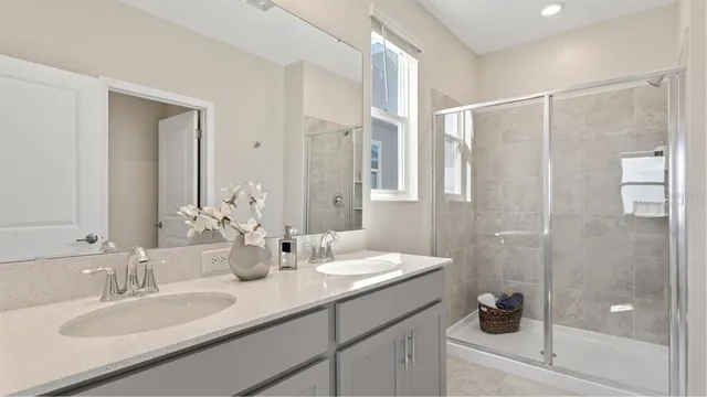 a bathroom with a double vanity sink mirror and shower