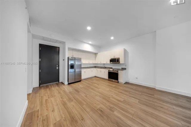 a view of a kitchen with a sink oven cabinets and staircase