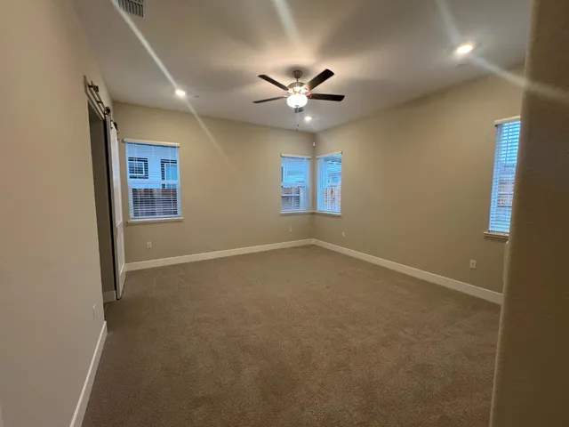 an empty room with a ceiling fan and a window