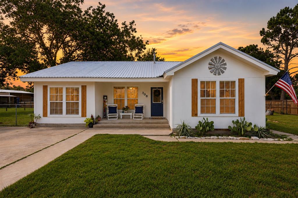 308 West 1st Street Springtown, TX 76082 - Photo 1 of 39 White exterior with a metal roof and a prominent gable accent