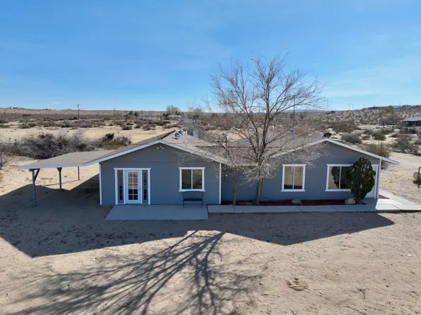 a front view of a house with a yard covered in snow