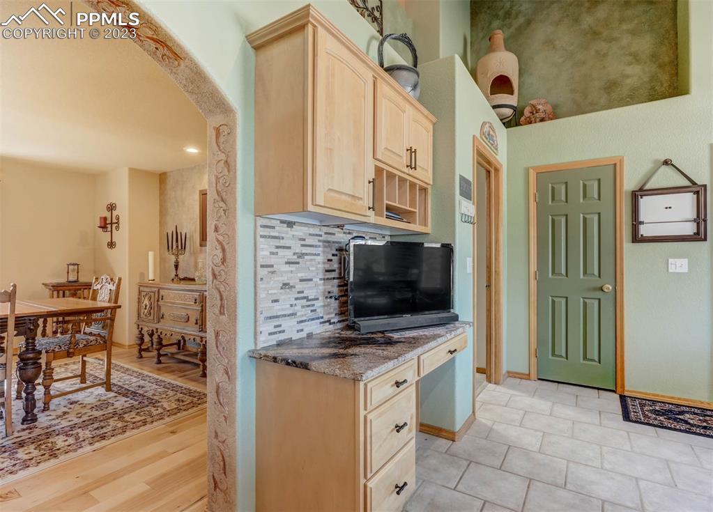 17305 Goshawk Road Colorado Springs, CO 80908 - Photo 23 of 50 a kitchen with stainless steel appliances kitchen island granite countertop a stove a sink and a microwave
