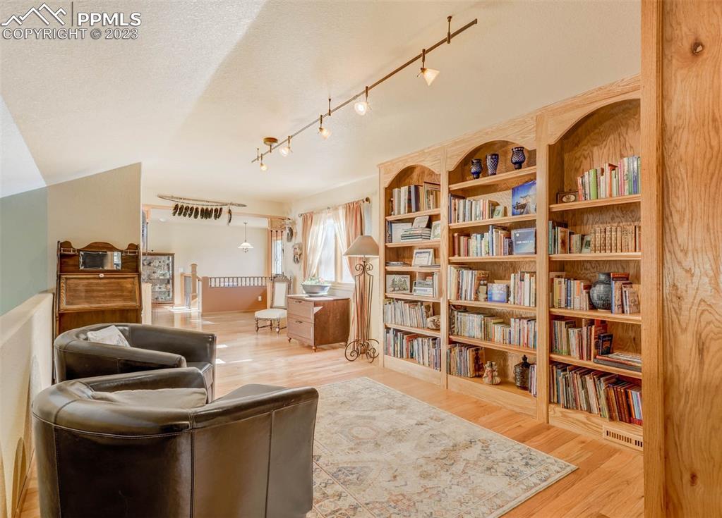 17305 Goshawk Road Colorado Springs, CO 80908 - Photo 36 of 50 a living room with furniture and a book shelf