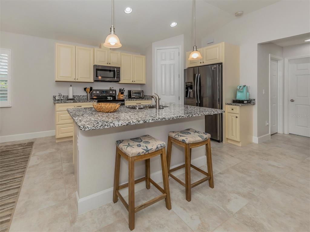 236 Holly Road Venice, FL 34293 - Photo 15 of 88 a kitchen with stainless steel appliances granite countertop a stove a sink and a refrigerator