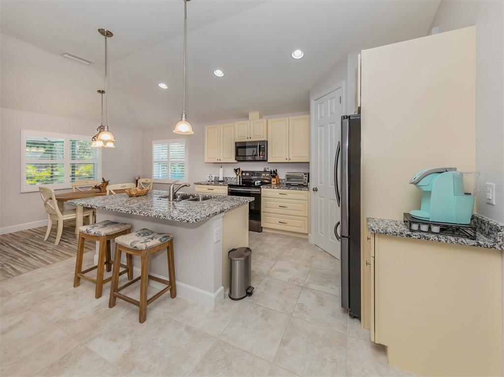 236 Holly Road Venice, FL 34293 - Photo 17 of 88 a kitchen with refrigerator and chairs