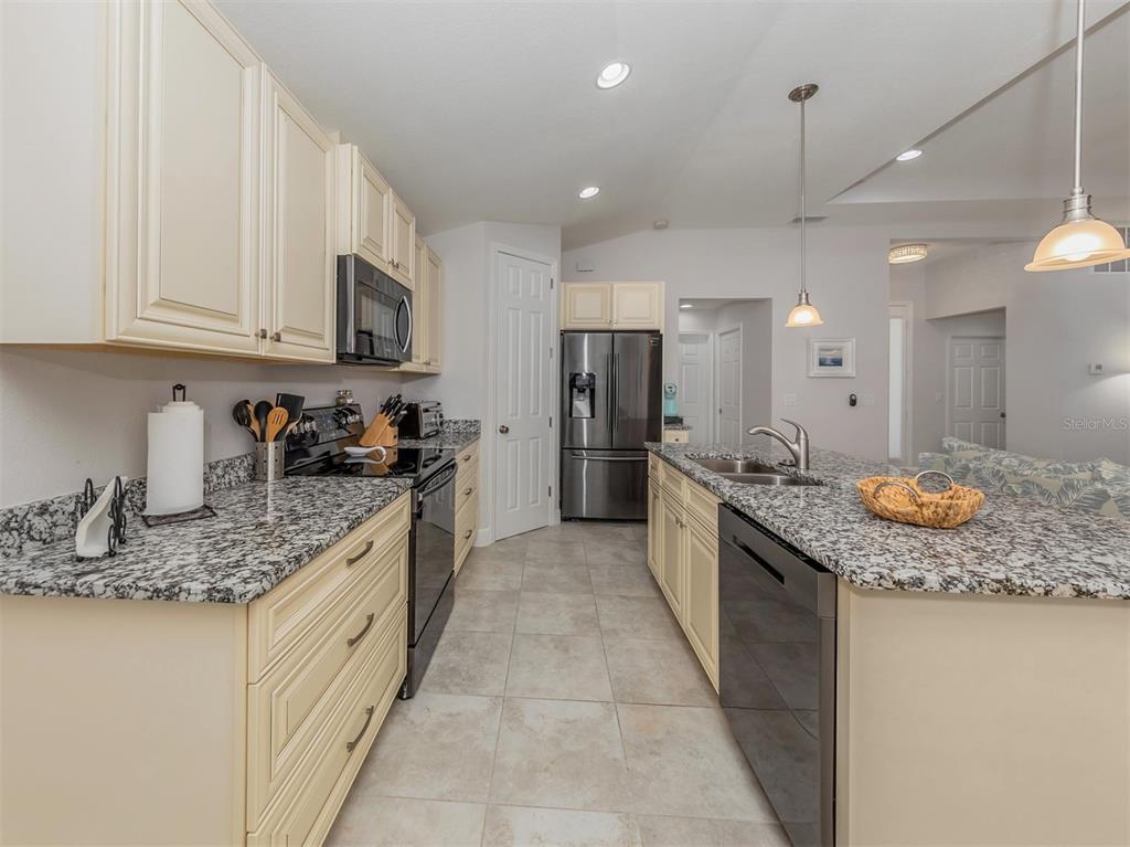 236 Holly Road Venice, FL 34293 - Photo 18 of 88 a large kitchen with stainless steel appliances granite countertop a sink stove and refrigerator