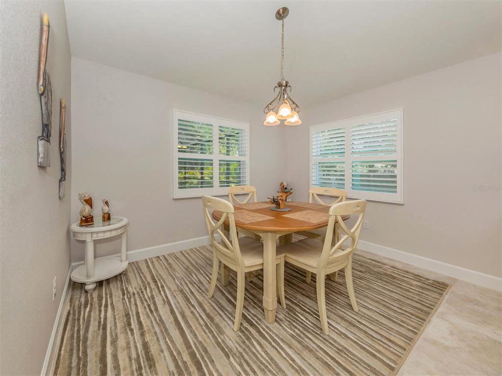 236 Holly Road Venice, FL 34293 - Photo 20 of 88 a dining room with furniture a chandelier and wooden floor