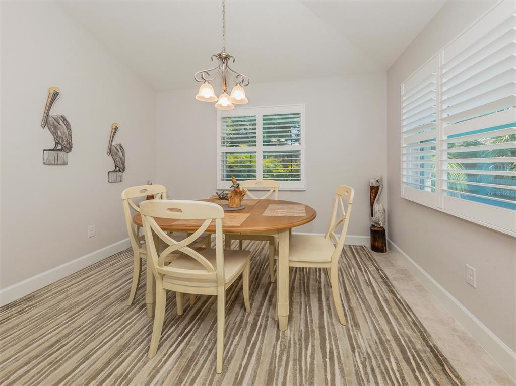 236 Holly Road Venice, FL 34293 - Photo 21 of 88 a view of a dining room with furniture wooden floor and chandelier