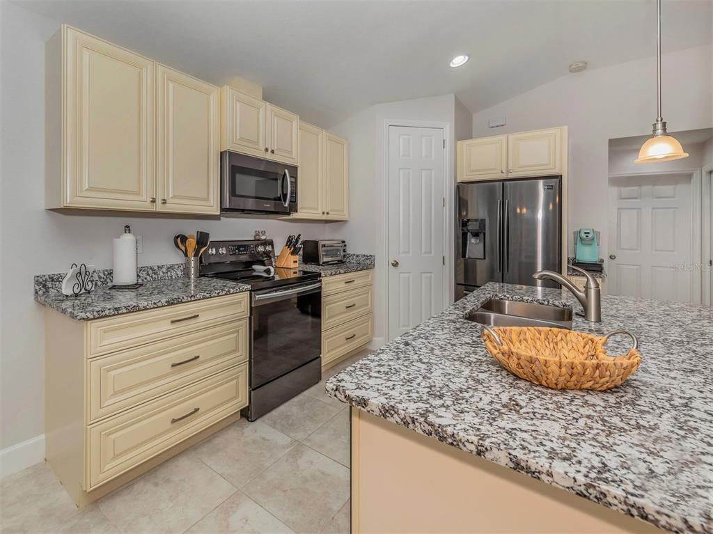 236 Holly Road Venice, FL 34293 - Photo 23 of 88 a kitchen with granite countertop stainless steel appliances a stove a sink a refrigerator a counter top space and cabinets