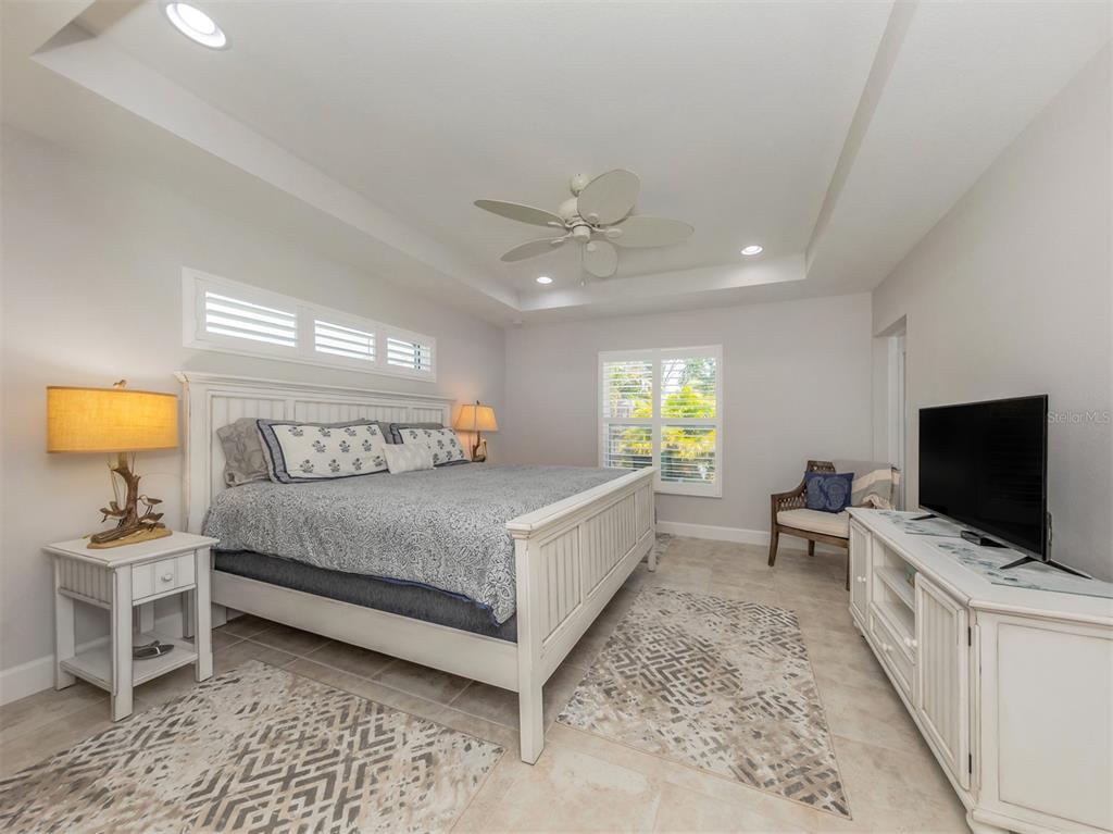 236 Holly Road Venice, FL 34293 - Photo 24 of 88 a bedroom with a bed and a flat screen tv