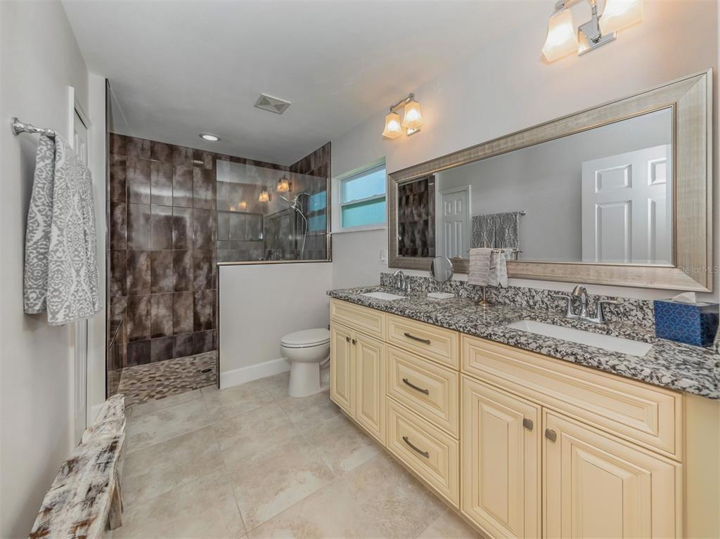 236 Holly Road Venice, FL 34293 - Photo 26 of 88 a spacious bathroom with a granite countertop sink mirror and shower